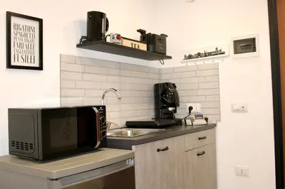 a kitchen with a microwave and a sink at Pillis House, accogliente appartamento in centro città, vicino al Politeama Palermo in Palermo