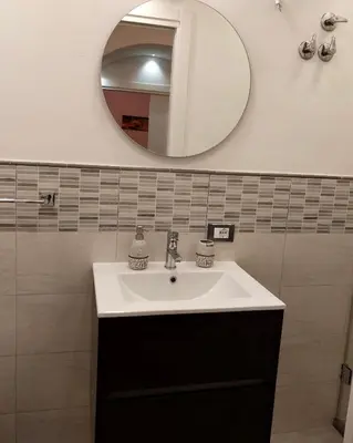 a bathroom with a sink and a mirror at Palermo Holiday Room in Palermo