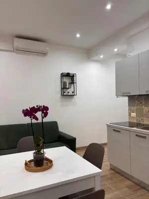 a kitchen with a table with a vase with a flower on it at Garzilli Cozy Apartment in Palermo