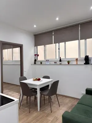 a living room with a white table and chairs at Garzilli Cozy Apartment in Palermo