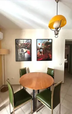 a dining room with a wooden table and green chairs at Fajra house in Palermo