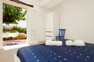 a bedroom with a blue bed and a blue chair at Villa Due Pini con piscina privata in Alcamo