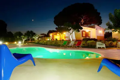 a swimming pool in front of a house at night at Villa Due Pini con piscina privata in Alcamo