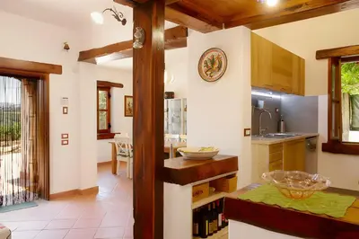 a kitchen with white walls and wooden ceilings at Villa Due Pini con piscina privata in Alcamo