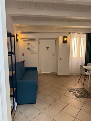 a living room with a blue couch and a door at bonito apartment in Palermo