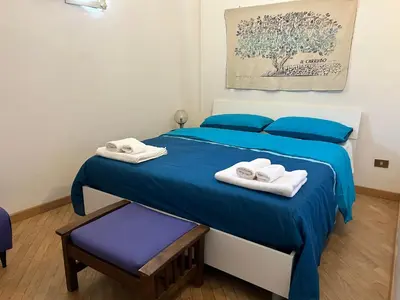 a bedroom with a blue bed with towels on it at Glicine House in Palermo