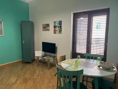 a living room with a table and a television at Glicine House in Palermo