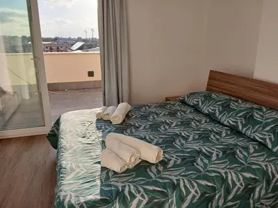 a bedroom with a bed with two towels on it at HolidayHouse Belvedere in Terrasini