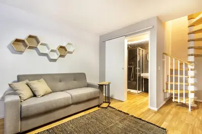 a living room with a couch and a staircase at Alloro Apartment 9 in Palermo