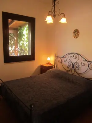 a bedroom with a bed and a mirror and a window at Oasi del Sole- sun and sea - Casa Xenia in San Vito lo Capo