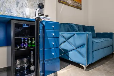 a blue couch next to a blue cabinet with wine bottles at D'ossuna66 Classic in Palermo
