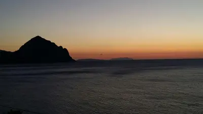 a sunset over the ocean with a mountain in the distance at Oasi del Sole - sun and sea -Casa Colombo in San Vito lo Capo