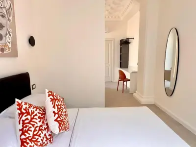 a yellow vase on a table with a bed at Villa di Nera boutique villa in Palermo