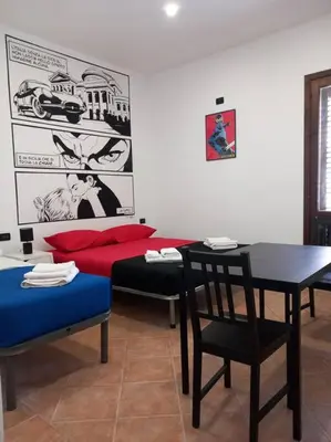 a room with a bed and a table and chairs at Piliero room in Palermo