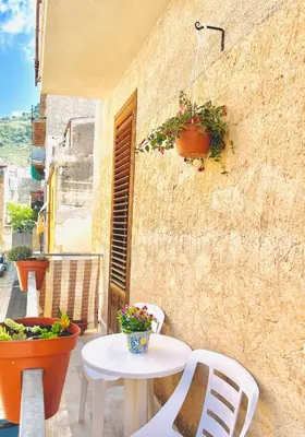 a patio with a table and chairs on a building at Michelle Holiday House in Castellammare del Golfo