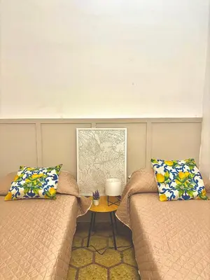 a room with two beds and a table at Michelle Holiday House in Castellammare del Golfo