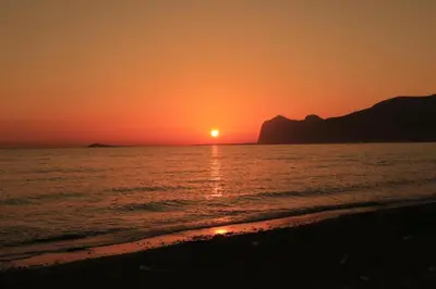 a sunset on the beach with the sun setting at Suite Vicino al Mare in Carini