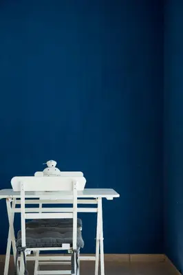 a white table with a blue wall and a white chair at Casa Azul in Castellammare del Golfo