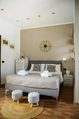 a bedroom with a bed with a clock on the wall at Locazione Turistica Aurora in Palermo