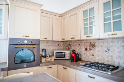 a kitchen with white cabinets and a stove top oven at Locazione Turistica Aurora in Palermo