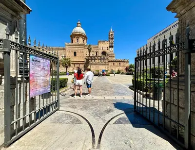 two people walking through the gates of a building at Dimore D'amare in Palermo