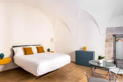 a bedroom with a bed and a table at Dimore D'amare in Palermo