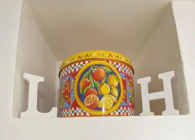a colorful vase in a box with the word h at Little House in Palermo