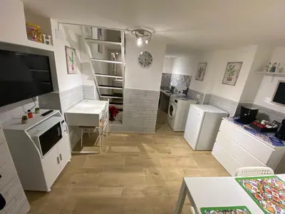 a large kitchen with white appliances in a room at Little House in Palermo