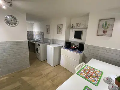 a kitchen with white appliances and a table in a room at Little House in Palermo