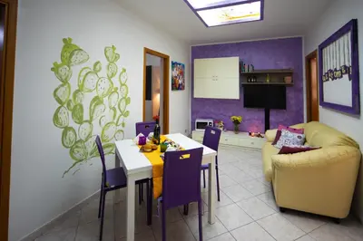 a living room with a table and chairs and a couch at My House Holiday Apartment in Palermo