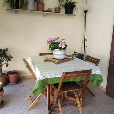 a table and chairs with a pot of flowers on it at B&B SoleLuna della Solidarietà in Palermo