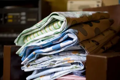 a pile of folded newspapers sitting on a table at B&B SoleLuna della Solidarietà in Palermo
