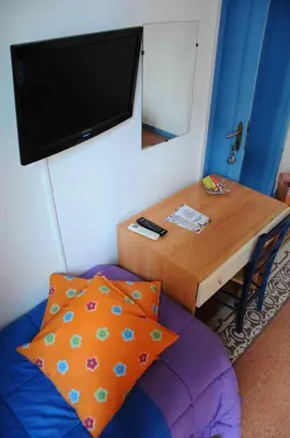 a room with a table and a tv on the wall at B&B SoleLuna della Solidarietà in Palermo