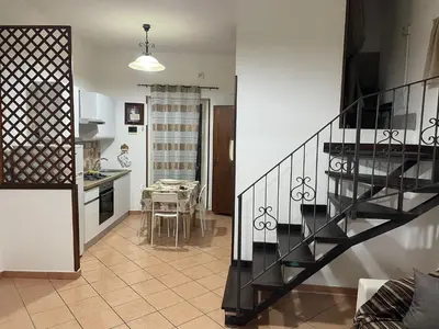 a living room with a staircase and a kitchen at Casa Vacanze Corale in Palermo