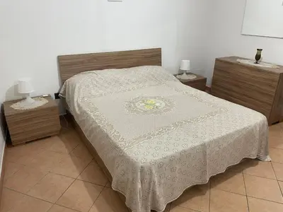 a bedroom with a bed and two nightstands with two lamps at Casa Vacanze Corale in Palermo