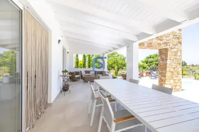 a white dining room with a white table and chairs at Villa Irene Deluxe in Campofelice di Roccella
