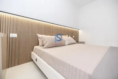 a bedroom with a large bed with a wooden headboard at Villa Irene Deluxe in Campofelice di Roccella