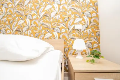 a bedroom with a bed and a yellow and white wallpaper at Central Room 128L in Palermo