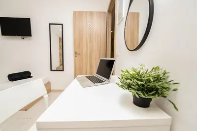 a white office with a laptop on a white desk at Central Room 128L in Palermo