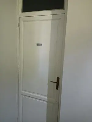 a white door with a sign on it in a room at La casetta della stazione in Palermo