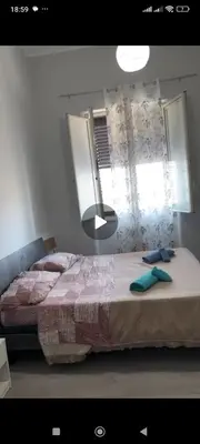 a bedroom with a bed with a mirror and a window at La casetta della stazione in Palermo
