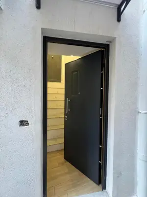 a black door in a room with a wooden floor at Kensia house - centro storico - stazione in Palermo