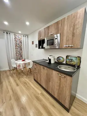 a kitchen with a sink and a microwave and a table at Kensia house - centro storico - stazione in Palermo