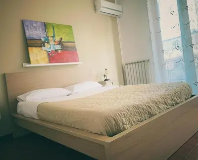 a bed in a bedroom with a painting on the wall at Marrakech Home in Palermo