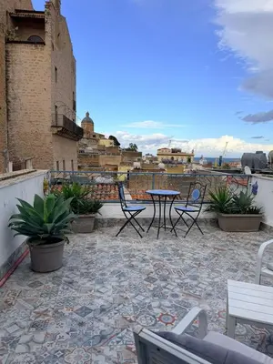 a patio with chairs and a table on a roof at Casa di Sylwia in Termini Imerese