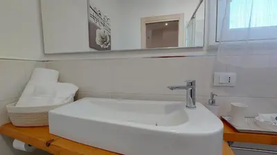 a bathroom with a white sink and a mirror at Amedeo Suite - Palermo Centro in Palermo