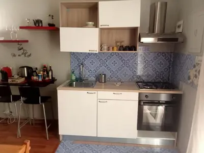 a kitchen with white cabinets and a table and chairs at Il balcone sulla Kalsa in Palermo