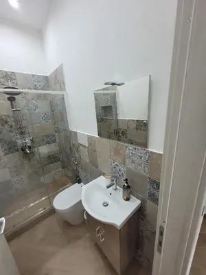 a bathroom with a sink and a toilet and a mirror at Sweet Home Maqueda in Palermo