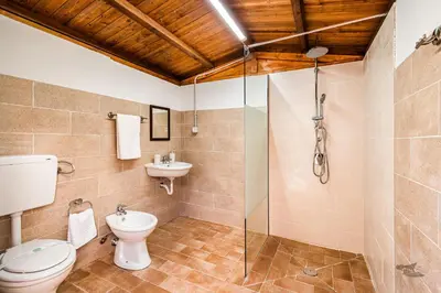 a bathroom with a toilet and a glass shower at Villa DelMarmo in Alcamo