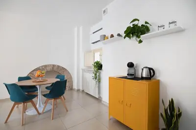 a kitchen with a table and chairs and a yellow cabinet at iFlat Le stanze del Principe in Palermo